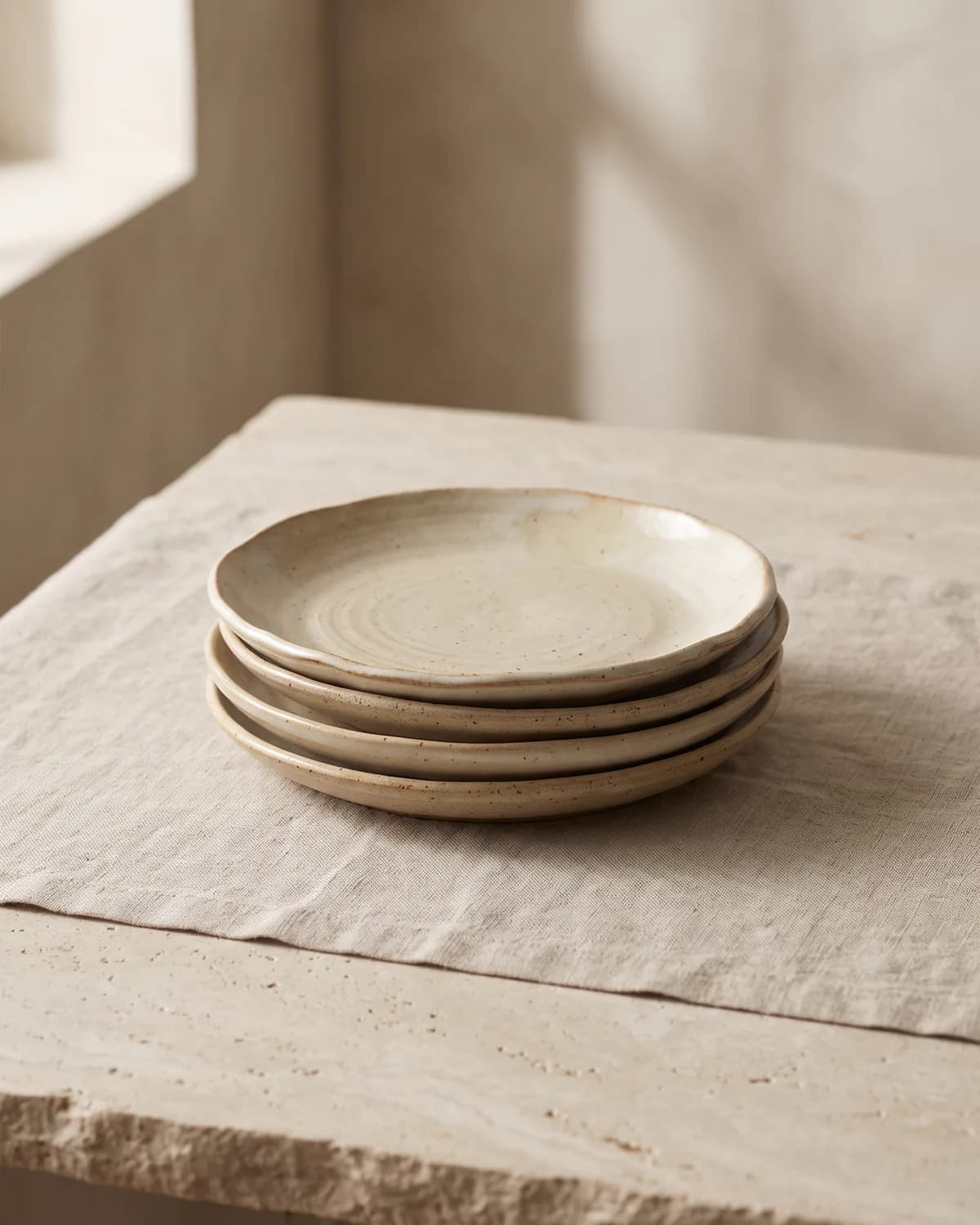 Stacked handmade ceramic plates in soft natural light